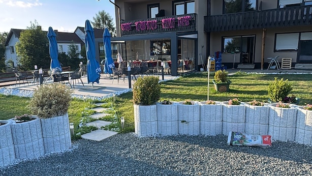 Un edificio con una fogata al frente, rodeado de grava.