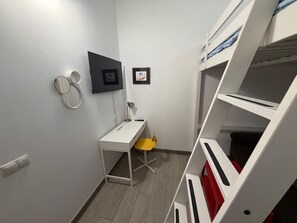 A compact room with a bunk bed, a desk, a chair, and a small window. - Las Palmas Castillo Albrit Community Center (Las Palmas de Gran Canaria)
