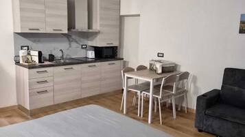 Una camera da letto moderna e minimalista con un letto grande, una scrivania e una sedia.