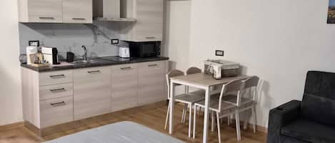 Un dormitorio moderno y minimalista con una cama grande, un escritorio pequeño y una silla.
