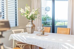 Ett matbord med en vas med blommor, två vinglas och en vinflaska.