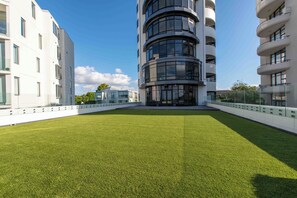 Een modern gebouw met een centrale binnentuin met kunstgras.