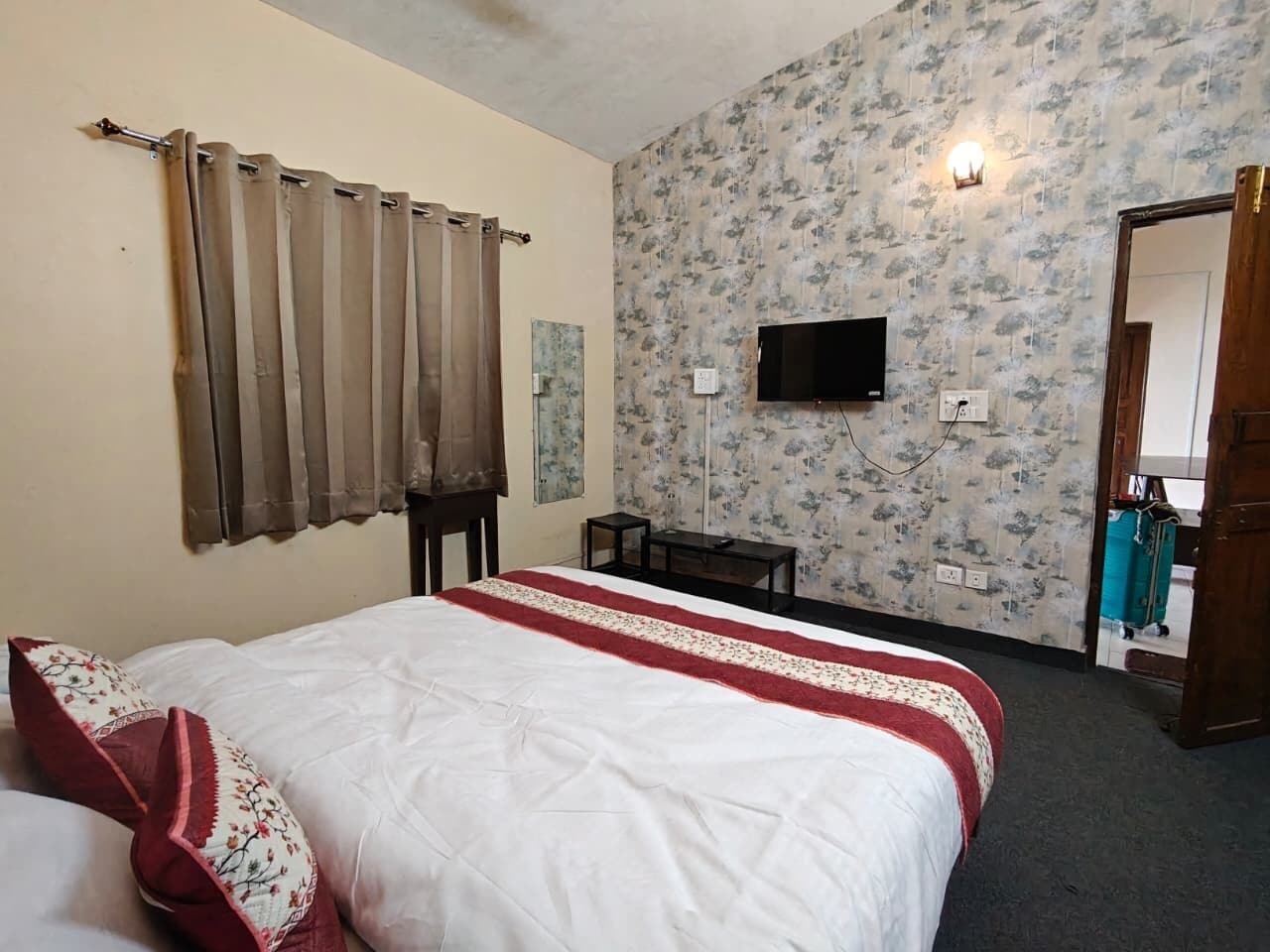 Ein Hotelzimmer mit einem Bett, einem Fernseher, einem kleinen Tisch und einem Spiegel.