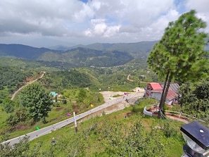 A mountainous landscape with a road, a bridge, and a small settlement with houses.