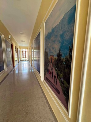 Un pasillo con un mural de un paisaje montañoso y un letrero que dice 'BADAMWARI'.