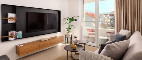 Uma sala de estar moderna com televisão de tela plana, armário de madeira e uma planta.