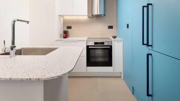 Una cocina moderna con encimera de granito, electrodomésticos de acero inoxidable y armarios azules.