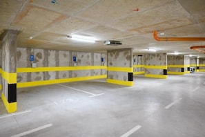 A multi-level parking garage with concrete walls, yellow safety lines, and numbered parking spaces.