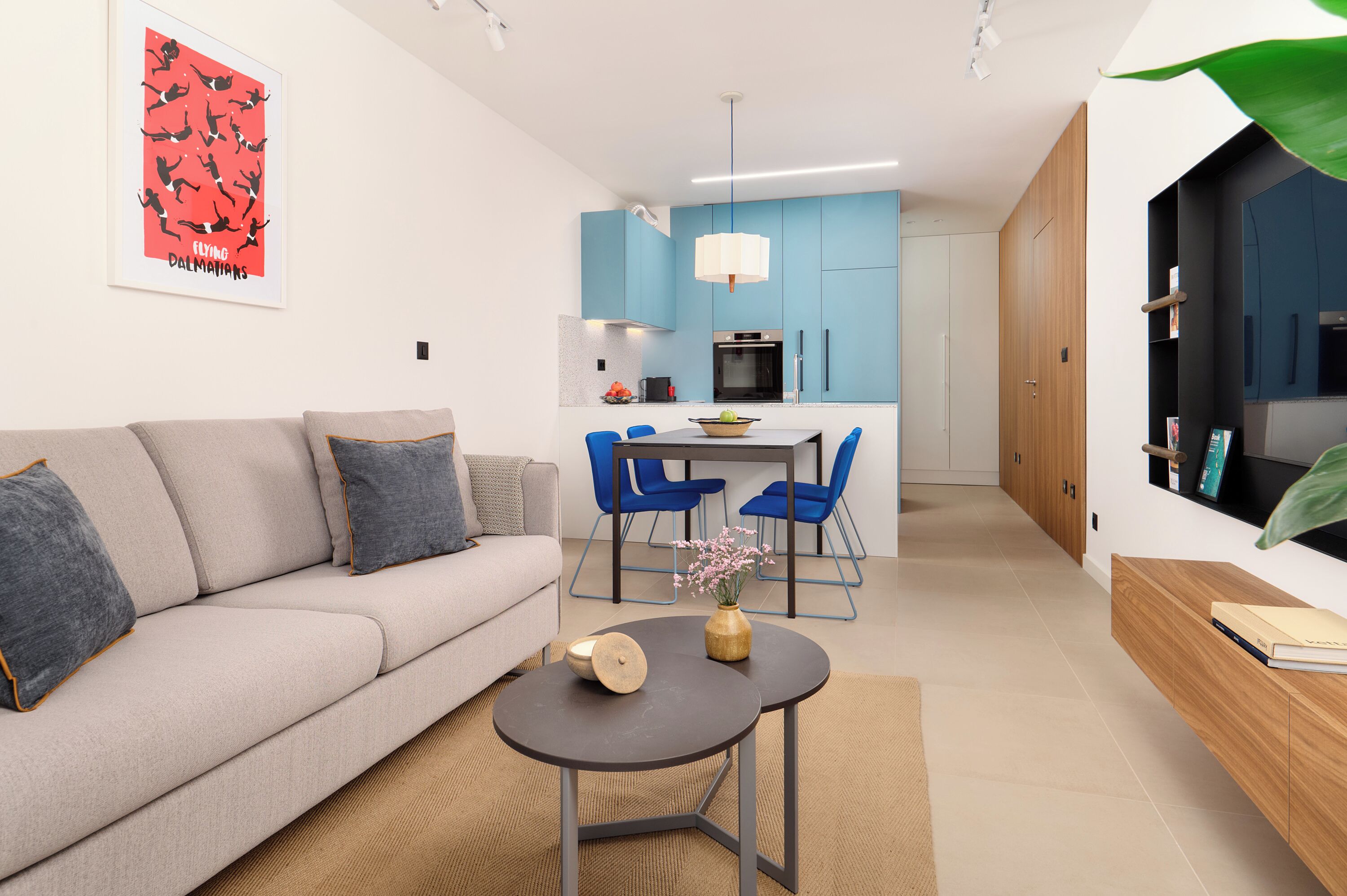 A modern living room with a sofa, coffee table, and blue chairs.