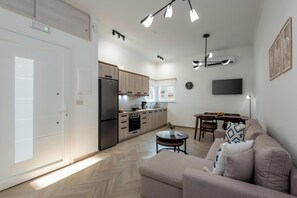A modern apartment with a kitchenette, dining area, and living room. - Marilianas Apartment (Platanias)