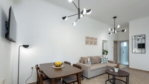 A modern living room with a dining table, sofa, and a small coffee table. - Marilianas Apartment (Platanias)