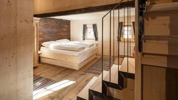 Un interior de madera con una cama, una escalera y una ventana.