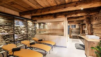 A rustic interior with stone walls, wooden beams, and a stone sauna.