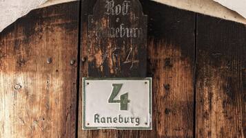 Una puerta de madera rústica con un cartel arriba que dice 'Rothenbürg' y un letrero más pequeño abajo con el número '4'.
