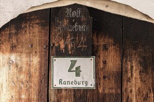 Una puerta de madera rústica con un cartel arriba que dice 'Rothenbürg' y un letrero más pequeño abajo con el número '4'.