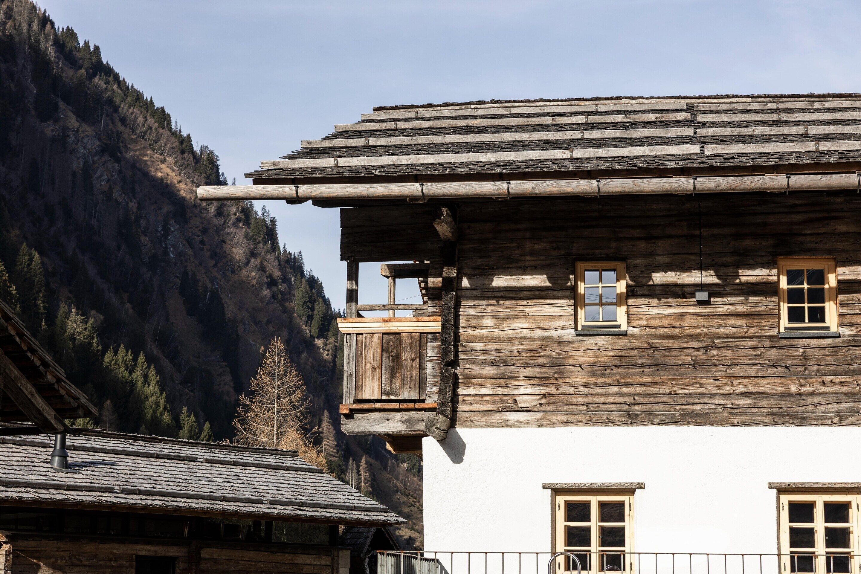 Un bâtiment traditionnel en bois, doté d’un toit en pente, de nombreuses fenêtres et d’un balcon.