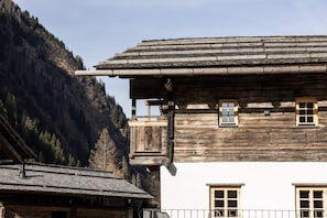 A traditional wooden building with a sloped roof, multiple windows, and a balcony. - Historic Chalet Raneburg (Matrei in Osttirol)