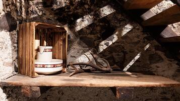 A rustic interior with a wooden shelf, a white ceramic basin, and antlers.