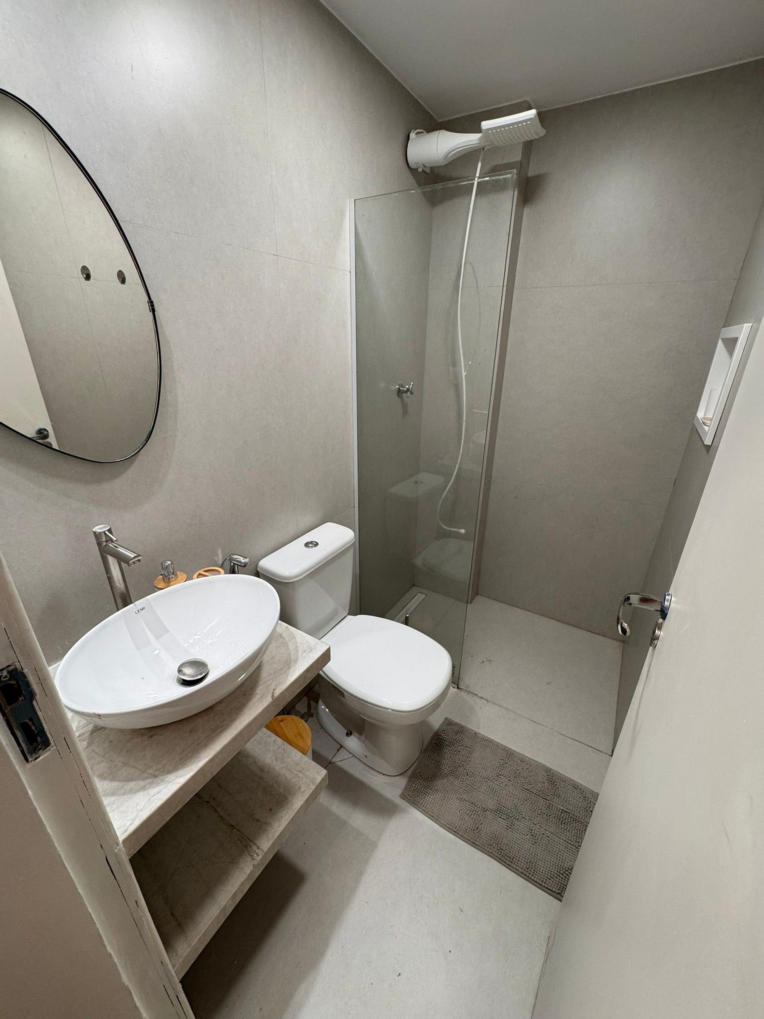 Un baño con lavamanos, inodoro y ducha.