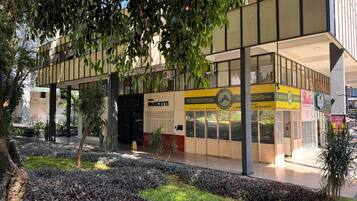 A commercial building with a storefront, outdoor seating area, and a landscaped garden.