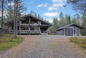 A log cabin with a porch and a separate garage. - Riekkoveska | Spacious 4BR Villa for Families (Ruka)