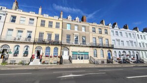 A row of terraced houses with a shop on the ground floor. - 123 On The Sea - The Cubby (Weymouth)