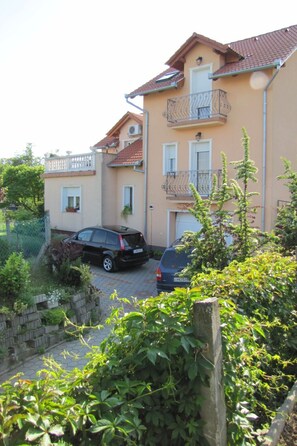 A residential building with a balcony, a car parked in front, and a garden area. - Alsohegyi apartmanok by Interhome (Zalakaros-Thermal)