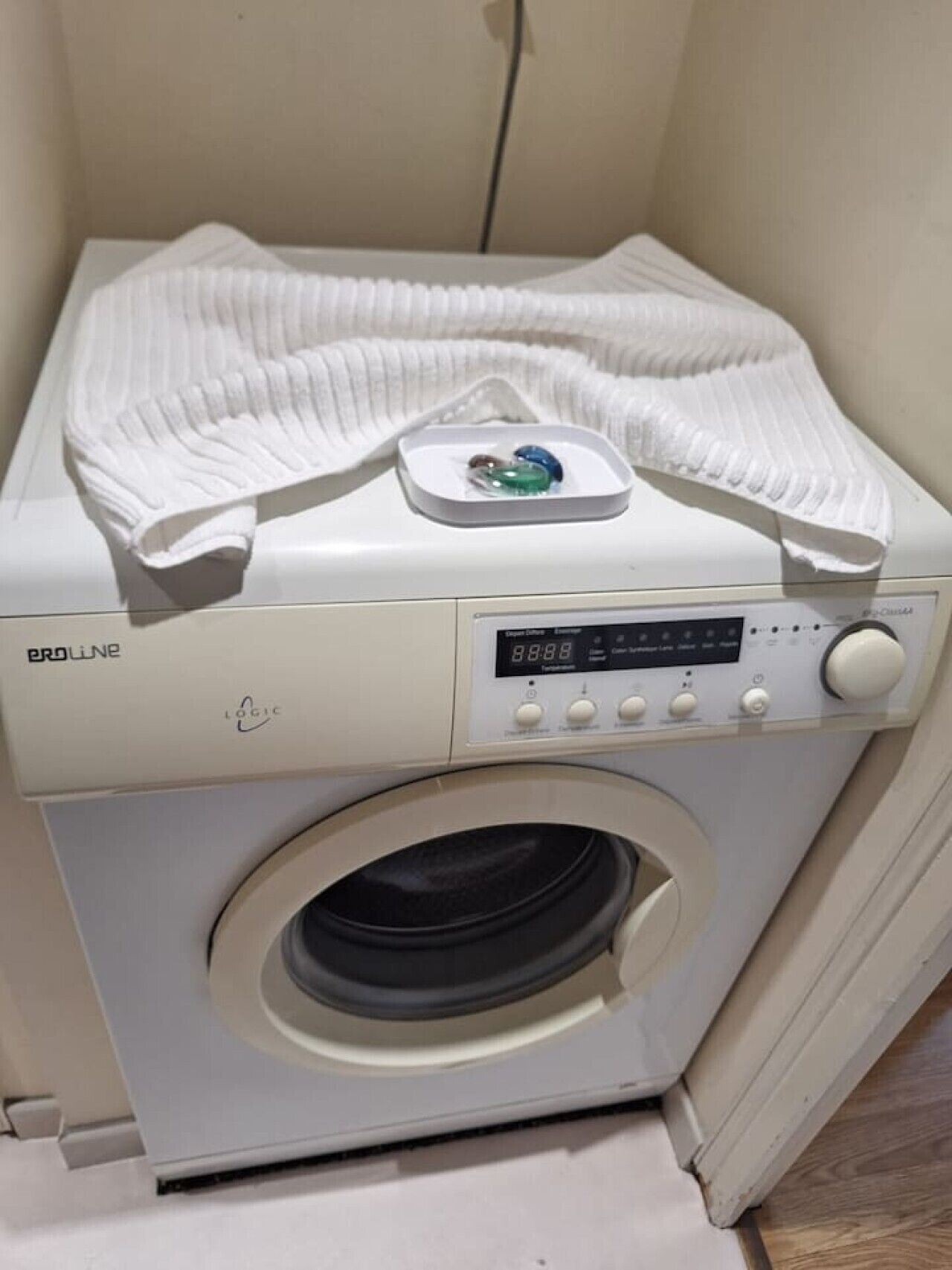 A front-loading washing machine with a digital display and control panel.