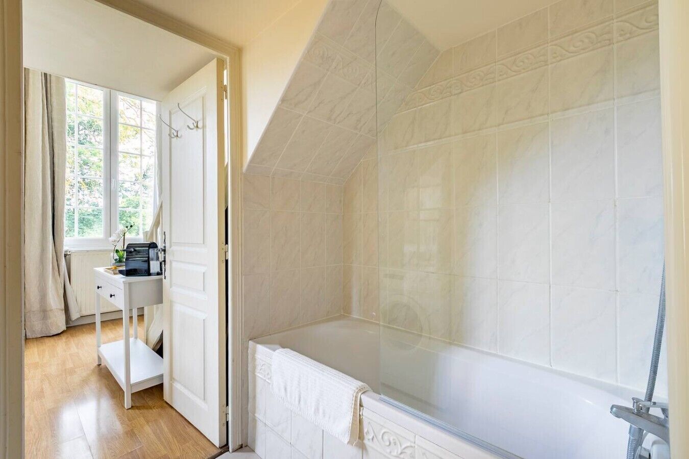 Un baño con bañera, ducha y ventana.