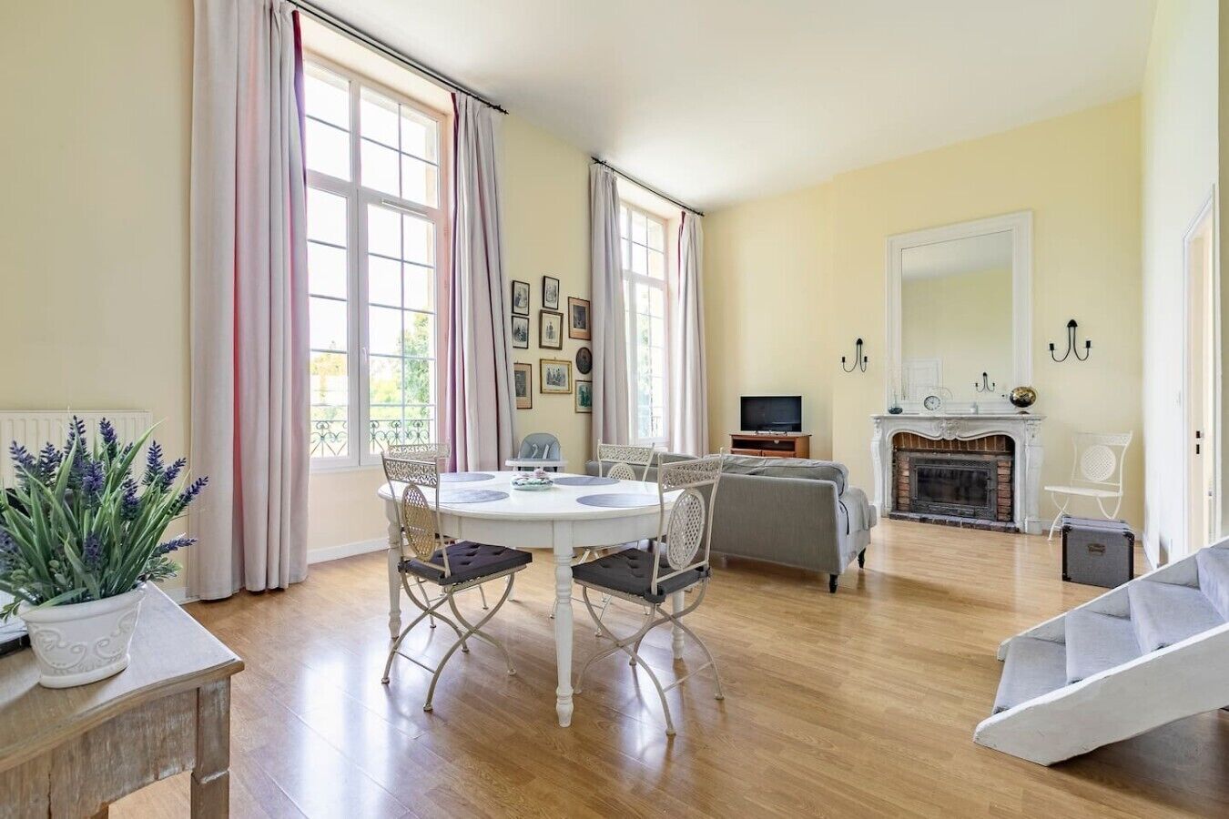 Amplia sala de estar con chimenea, comedor con mesa y sillas, y una zona de estar con sofá.