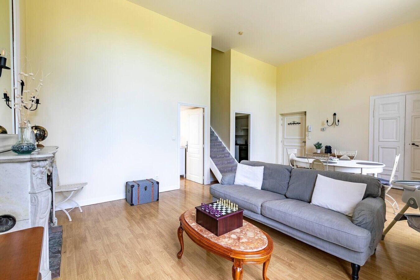 A living room with a grey sofa, a wooden coffee table, and a chessboard.