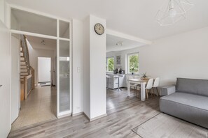 A modern interior with a staircase, a kitchen area, and a seating space.