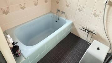 Un baño con bañera, ducha e inodoro.