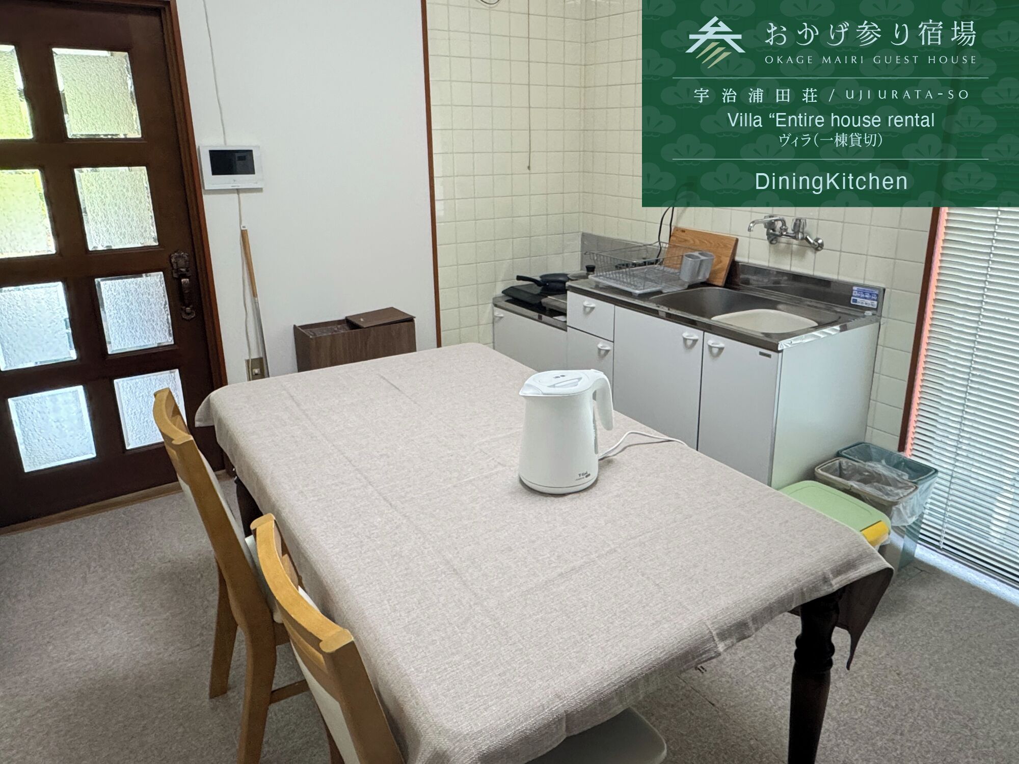 Un comedor con una mesa, sillas, un hervidor y una kitchenette.