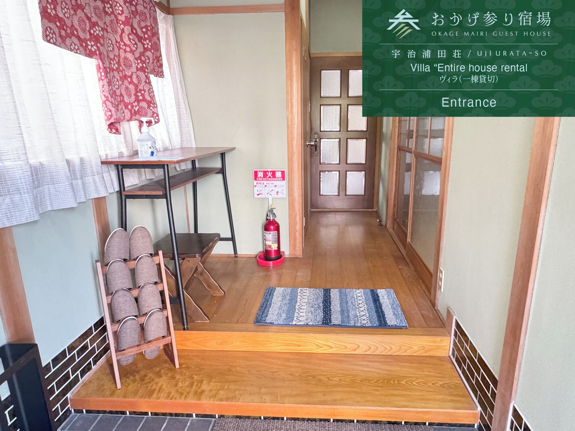 A narrow hallway leading to a door with a fire extinguisher mounted on the wall.
