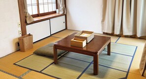 Um quarto japonês tradicional com tatames, uma mesa de madeira baixa e uma janela com portas shoji deslizantes.