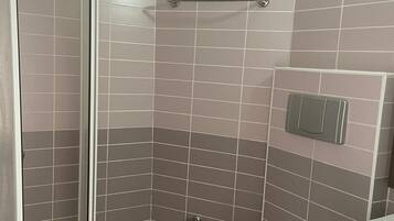 Baño con ducha, inodoro y lavamanos.
