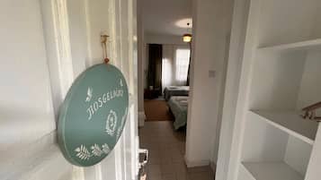 Un pasillo que conduce a una habitación con una cama y una ventana con cortinas.