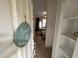 Un pasillo que conduce a una habitación con una cama y una ventana con cortinas.