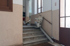 A staircase with a handrail, a door with a window, and a wall-mounted light fixture. - A welcoming and bright 85 square meters apartment, perfect for six people, located on the third floor of a period building with an elevator (NOT accessible to people with disabilities).The property enjoys an excellent location in Palermo (within the limi (Palermo)