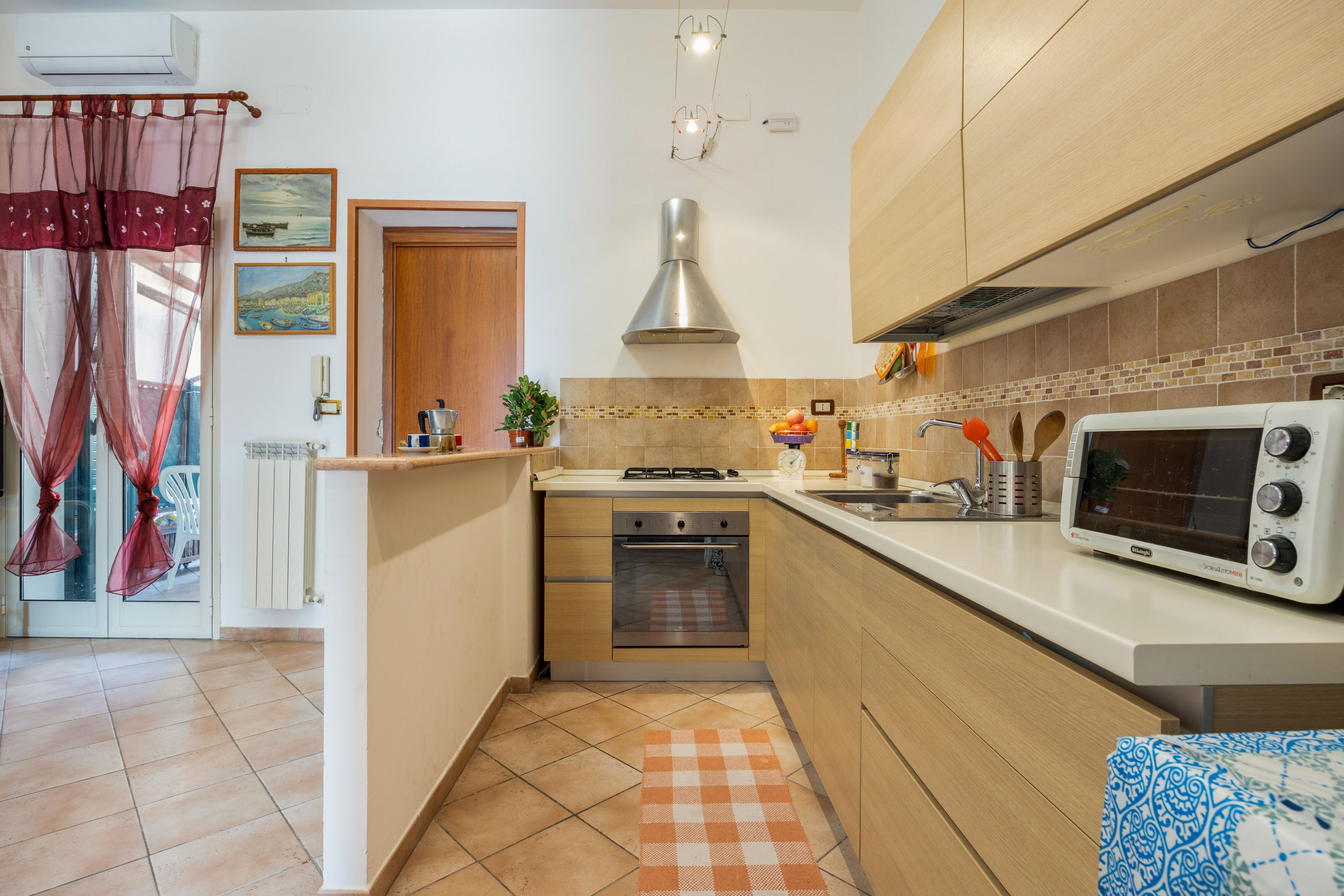 Een functionele keuken met een inbouwoven, een magnetron en een gasfornuis.