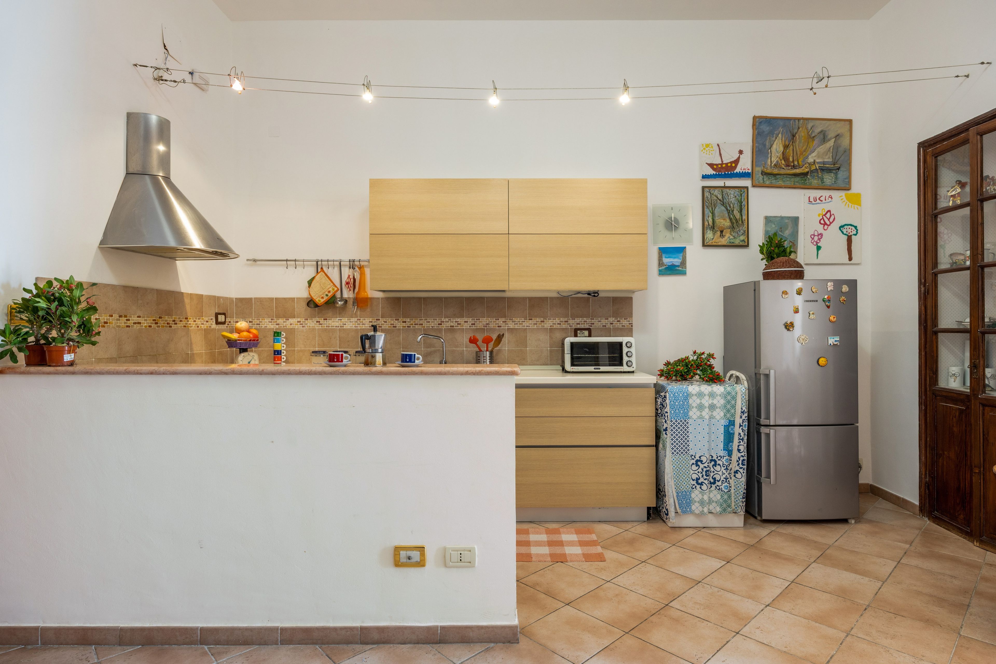 Eine moderne Küche mit einer zentralen Kochinsel, einem Backofen, einer Mikrowelle und einem Kühlschrank.