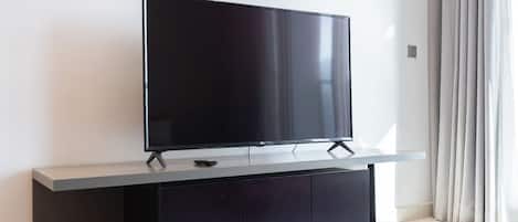 A flat-screen TV on a stand in a modern room with a minimalist design.