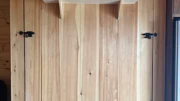 Une porte en bois avec une poignée en métal et une étagère au-dessus.