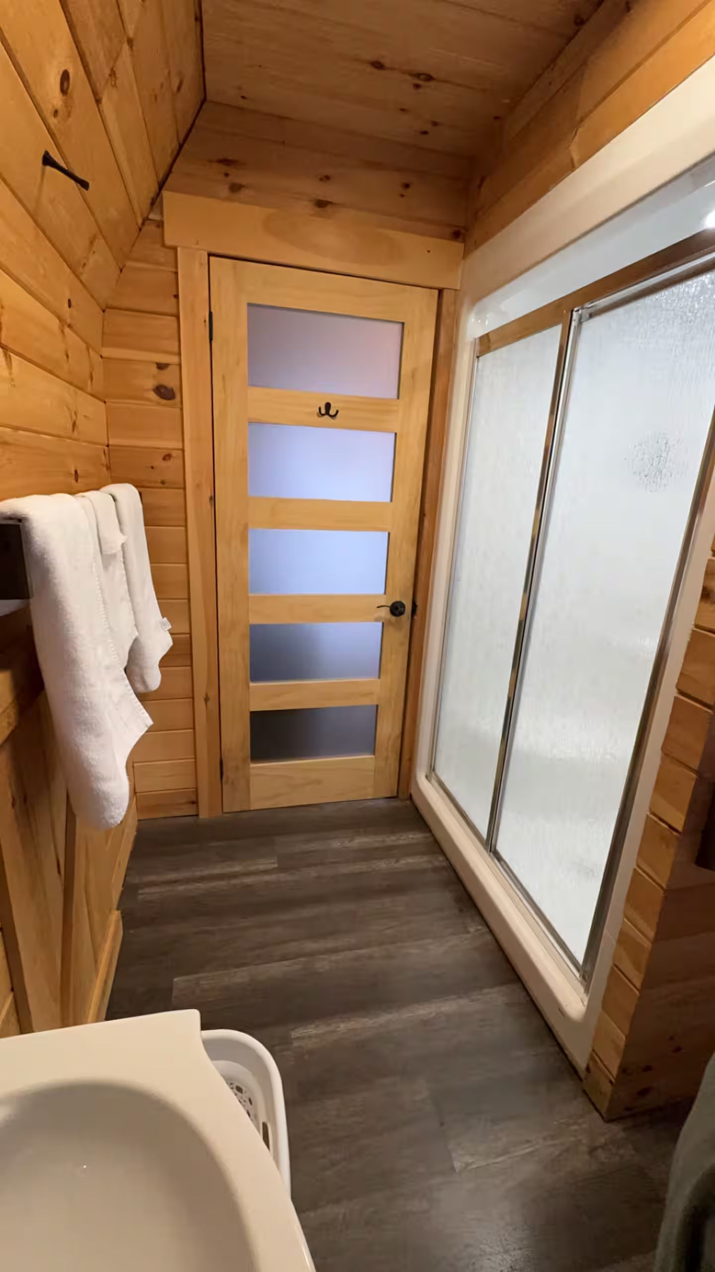Un interior de madera con un vidrio que da a un baño.