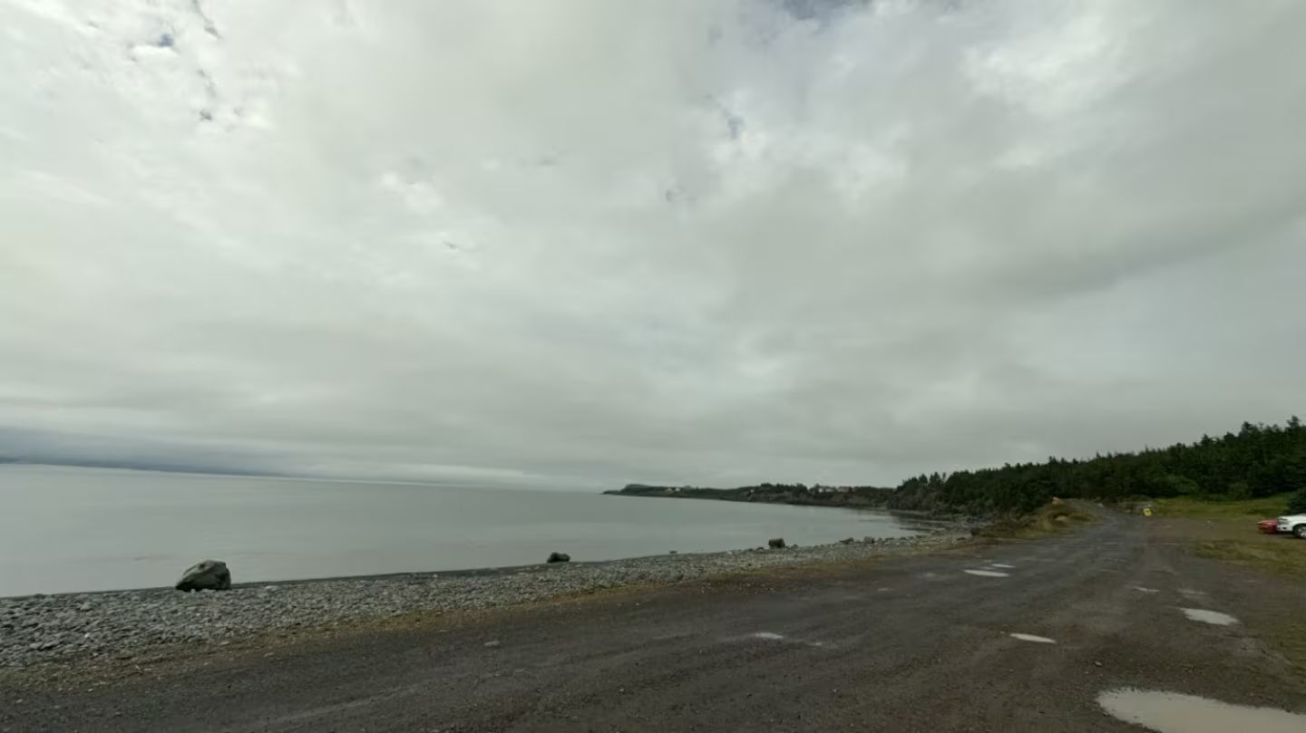 Una carretera costera con vistas al mar y una isla distante.
