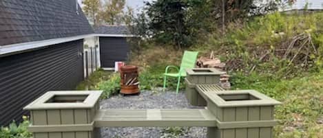A gravel area with two green planters and a green chair.