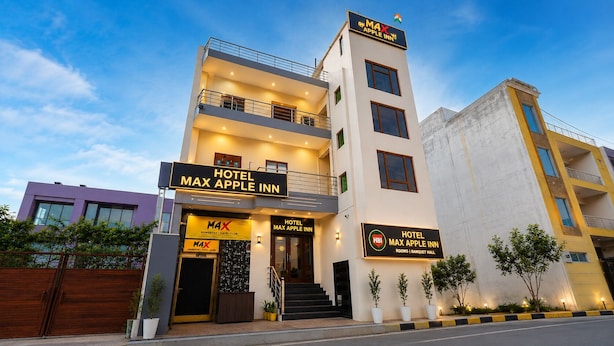 Un hotel modern amb un senyal ben visible per 'Hotel Max Apple Inn' i una entrada destacada.