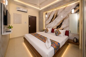 Habitación de hotel con cama, televisor, aire acondicionado, puerta y pared con diseño de mármol.