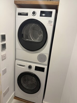 Eine gestapelte Bosch Waschmaschine mit Selbstreinigungsfunktion, Bedienfeld und digitalem Display.